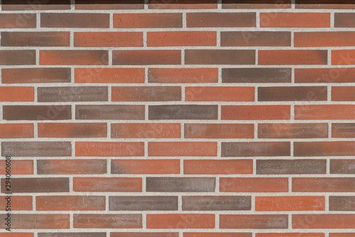 Wall of red and brown brick and gray cement joints. Abstract cozy background for design and title.