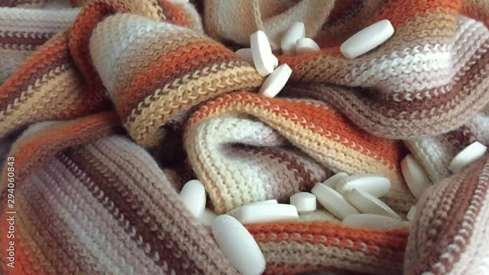 pills falling on a striped scarf pills falling on a striped scarf