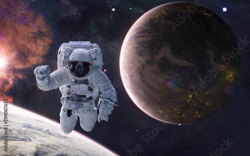 Astronaut on background of a colonized planet. Planets of deep space in warm starlight. Science fiction. Elements of this image furnished by NASA