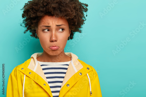 Foto Gloomy pity woman with curly hairstyle, has frowning upset face expression, purs
