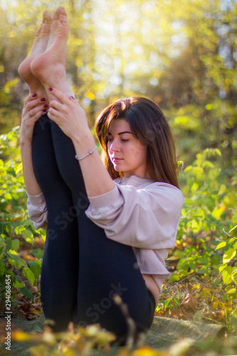 Beautiful woman doing yoga in autumn park