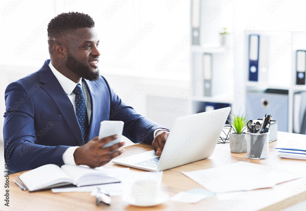 Fototapeta premium Happy businessman surfing internet on phone, working in office