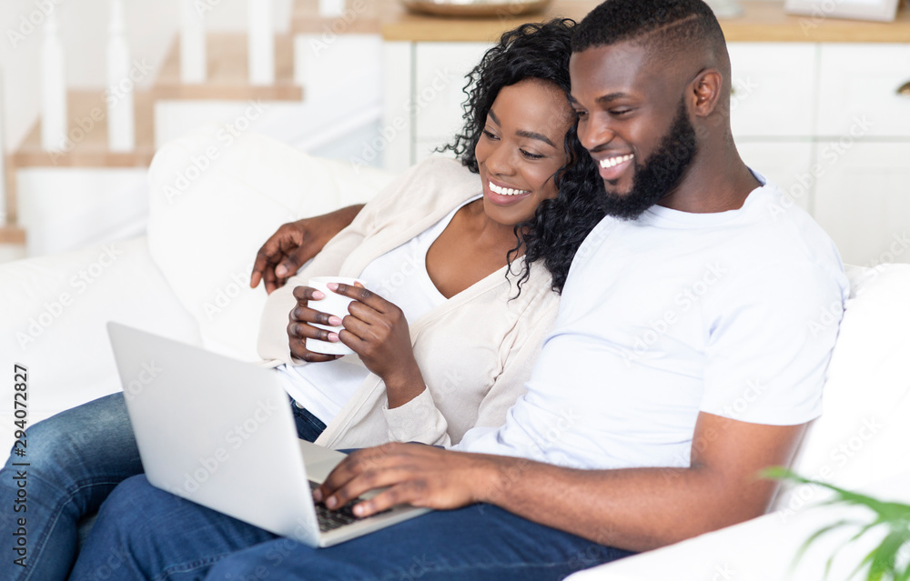 Happy African American man and woman enjoying movie on laptop Happy African American man and woman enjoying movie on laptop