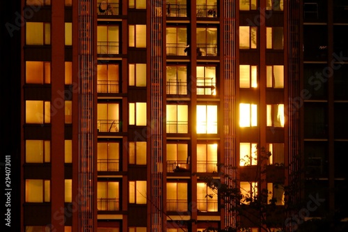 Silhouette sunset reflection on a city hight building glass at dusk with golden light shadow