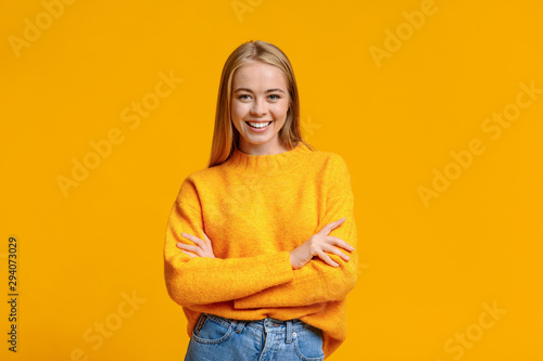 Beautiful young girl posing to camera with folded arms