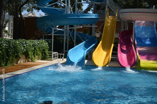 Little girl on water slide at aquapark during summer holiday