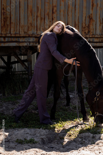 photo beautiful woman in the costume hugging horse