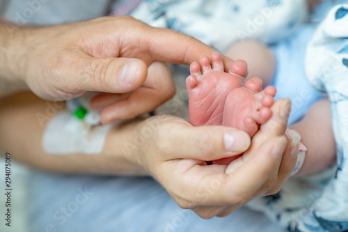 Stopy noworodka w dłoniach rodziców