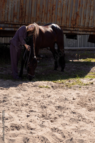 Pictures beautiful woman in a suit hugs a horse