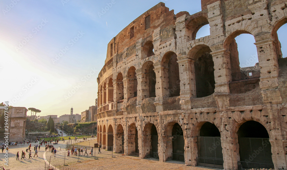 FLAVIAN THEATRE, ROME, ITALY - 2018: Many people gather at the Colosseum entrance at sundown.