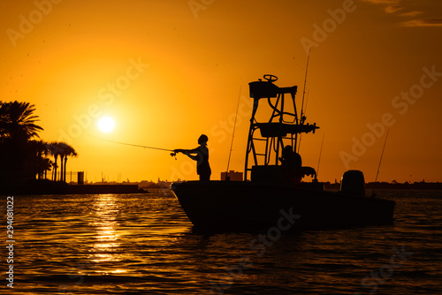 Man silhouette fishing on a boat