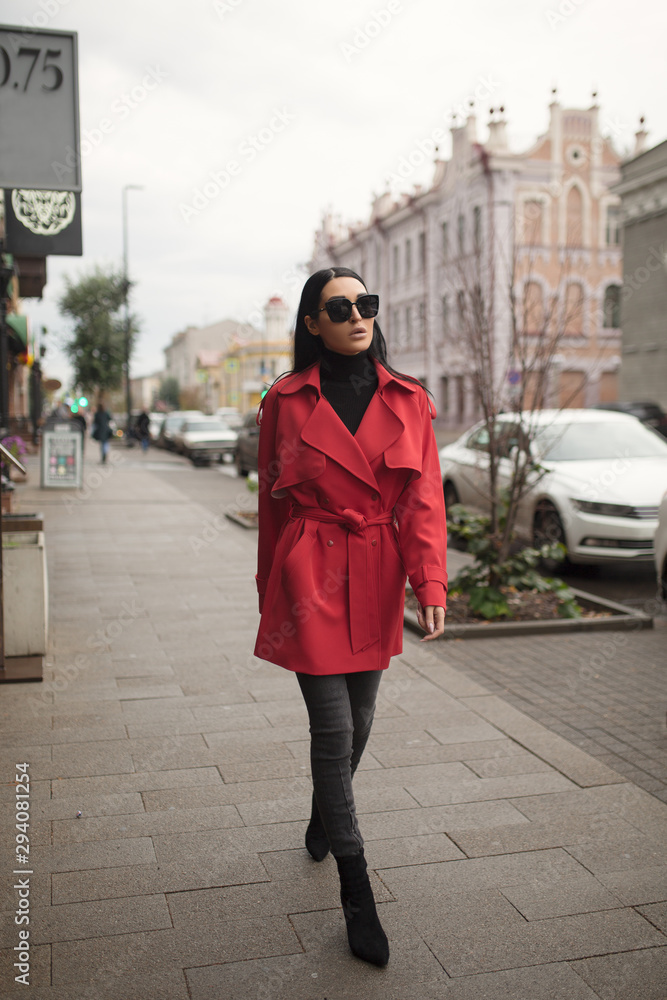Fototapeta premium Fashion step woman go to city. Red jacket