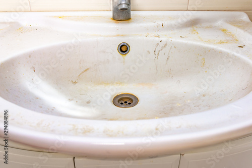 Fotografija Old dirty washbasin with rust stains, limescale and soap stains in the bathroom