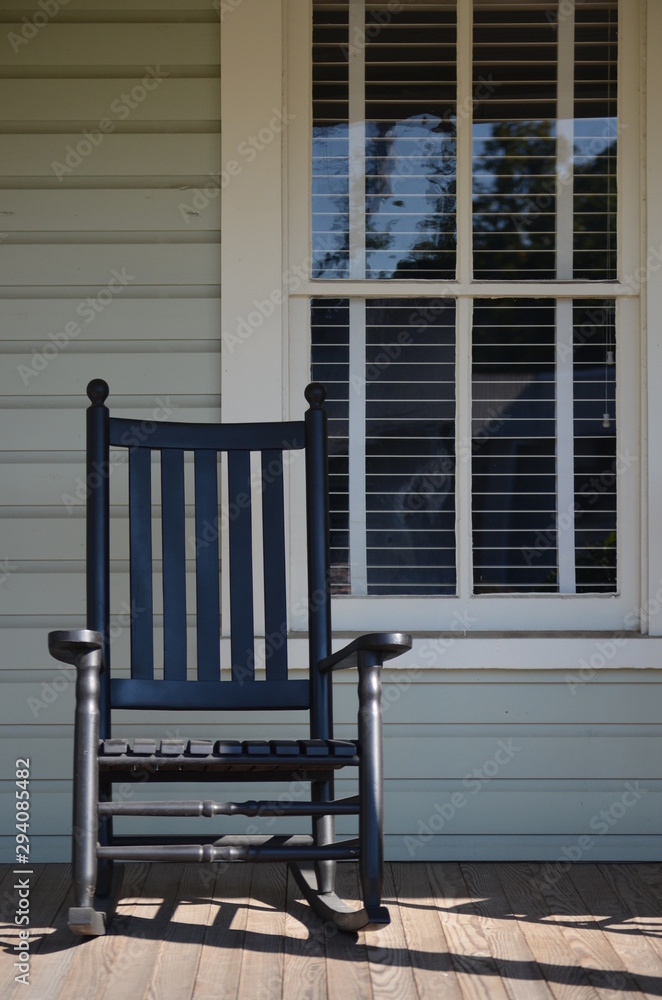Single rocking chair sitting on a porch Single rocking chair sitting on a porch