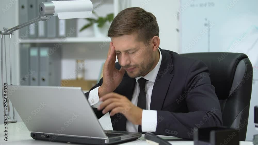 Company head working on laptop pc, suddenly feeling strong headache, health Company head working on laptop pc, suddenly feeling strong headache, health