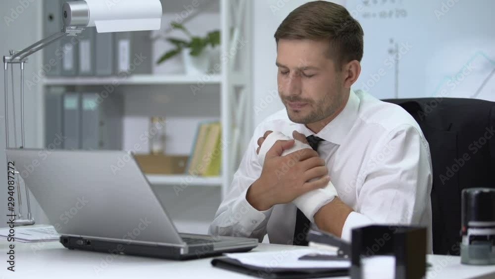 Workaholic man with broken arm in gypsum typing one hand on laptop pc, trauma Workaholic man with broken arm in gypsum typing one hand on laptop pc, trauma