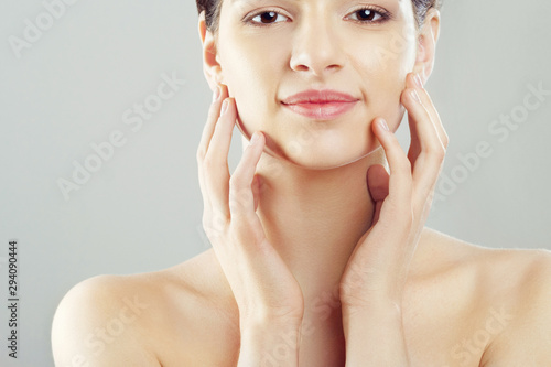 Beauty and Spa Concept. Beautiful Young Woman with Clean Fresh Skin touch own face and Smiling.Facial treatment. Girl Female With Natural Makeup.Cosmetology.
