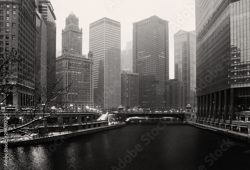 Urban architecture background. Chicago downtown view with skyscrapers along Chicago river and street illumination during beautiful snowy winter evening in monochrome. Midwest USA  Illinois.