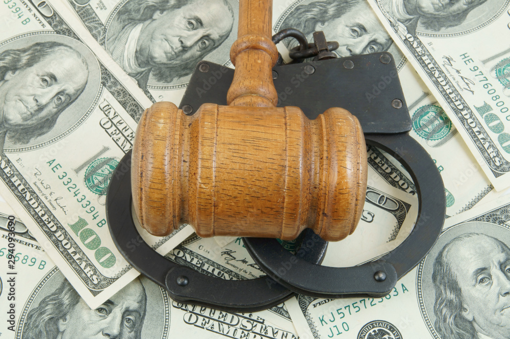 Gavel and handcuffs on money background