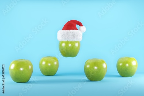 Green Apples with Santa Hat floating on blue background , Christmas Fruit concept ideas, 3D illustration. photo