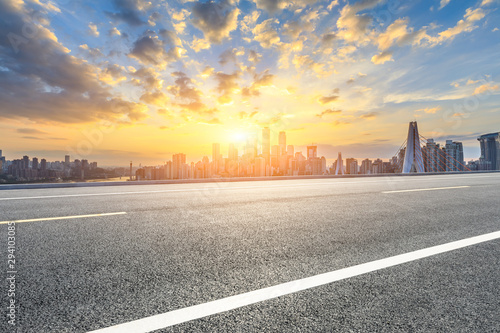 Asphalt highway and modern city financial district skyline in Chongqing at sunset China.