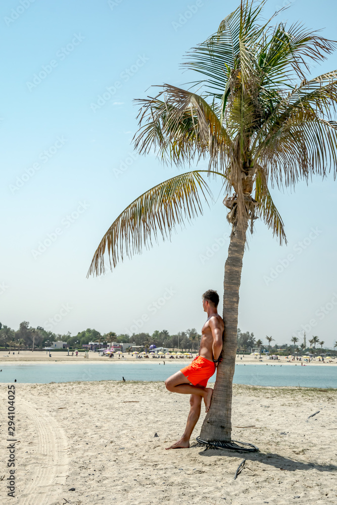 mężczyzna na rajskiej plaży z palmą