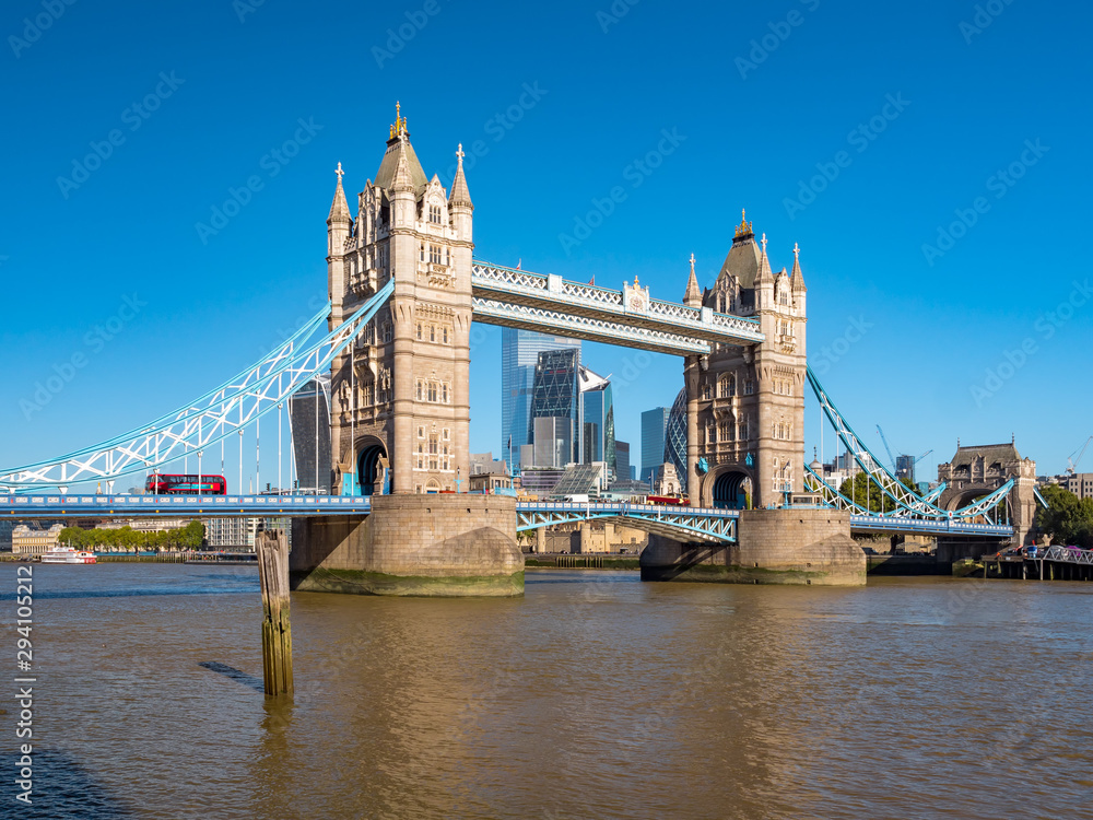 Obraz premium Panorama view of the Tower bridge over Thames river on a sunny day with the City Financial district skyscrapers and Tower of London in the background.