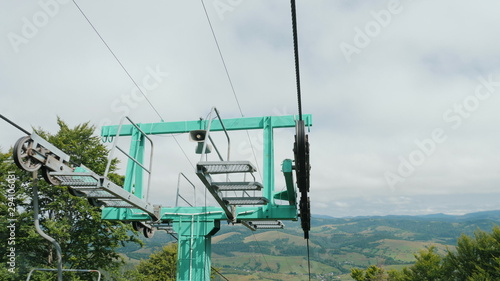 Moving on a cable car, funicular. View of ski lift mechanism on top of support pillar. Cableway support in the Carpathian mountains. Ukraine