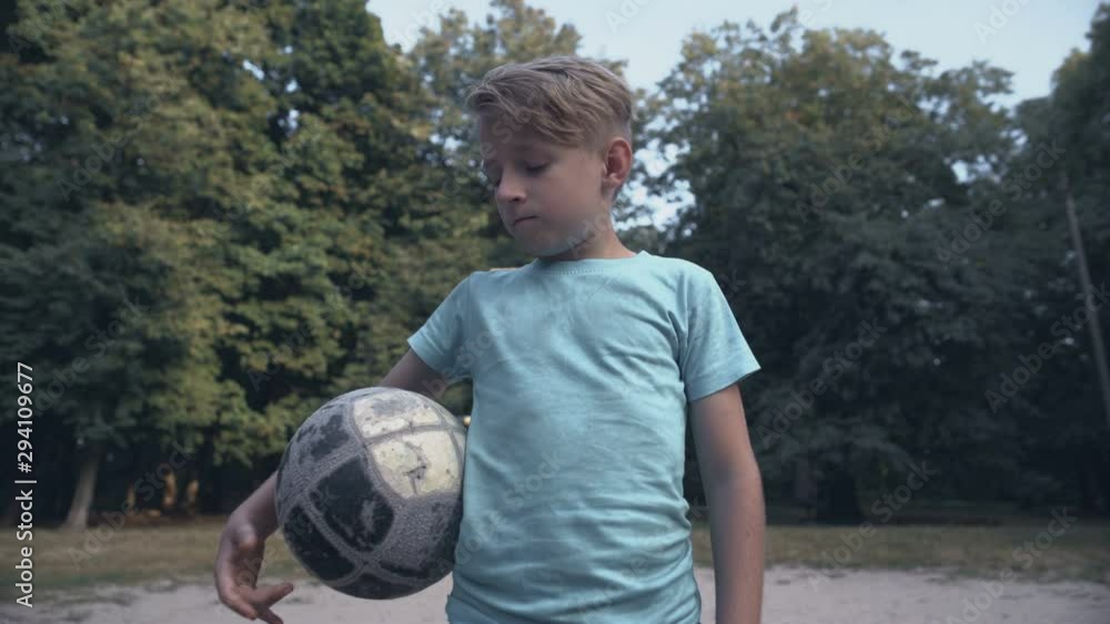 Lonely upset boy holding football at pitch, lack of friends, bullying problem Lonely upset boy holding football at pitch, lack of friends, bullying problem
