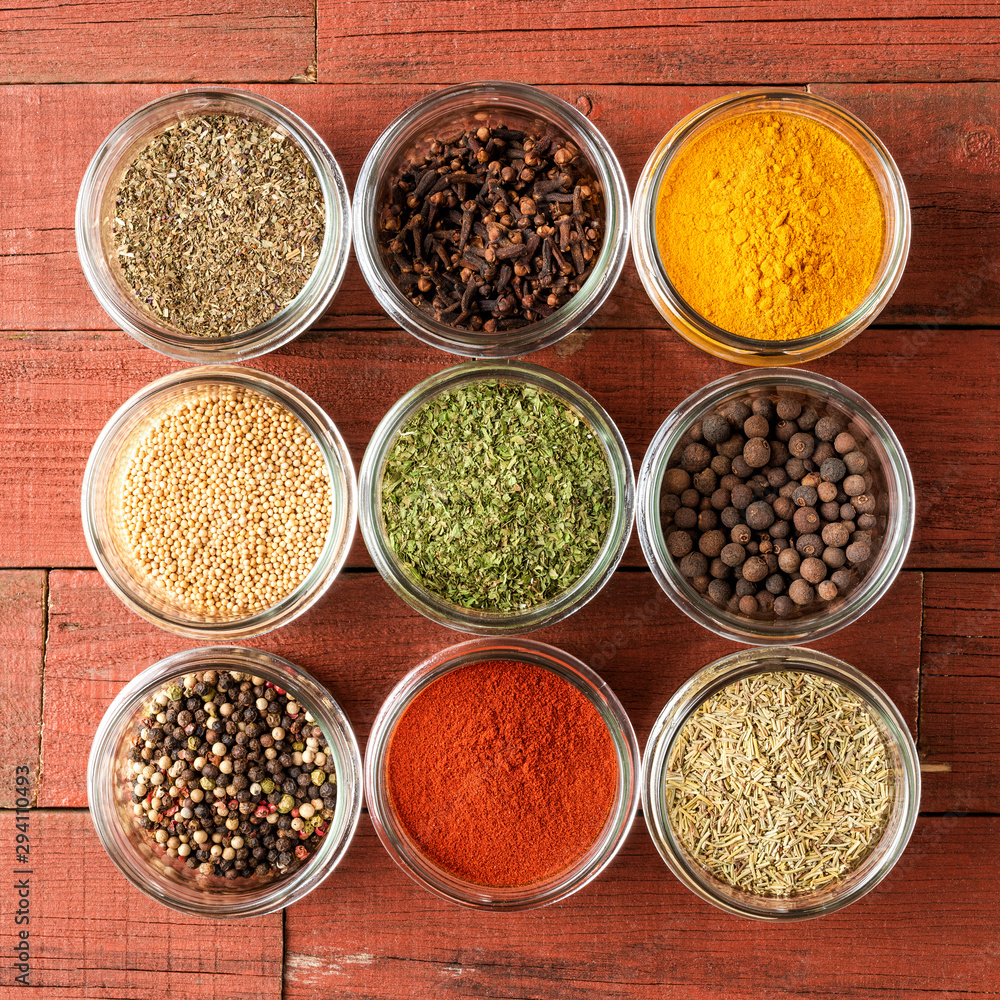 Colourful spices in bowls on wooden table. Big collection of spices. Top view