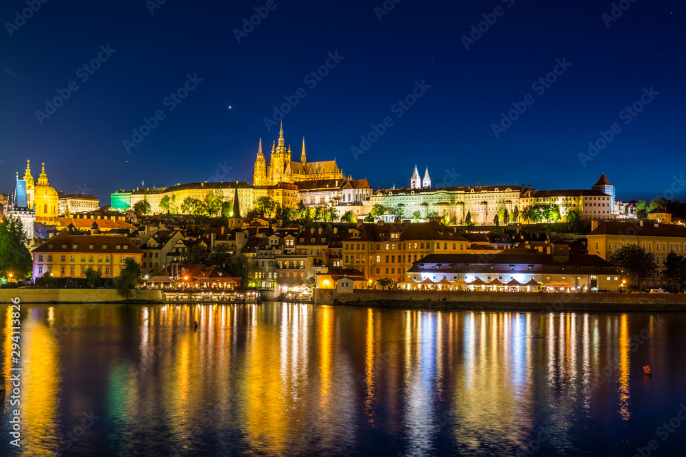 Night View of  the Lesser Town ( Mala Strana ) district and  Prague castle, the largest coherent castle complex in the world, with the reflection on Vltava river.