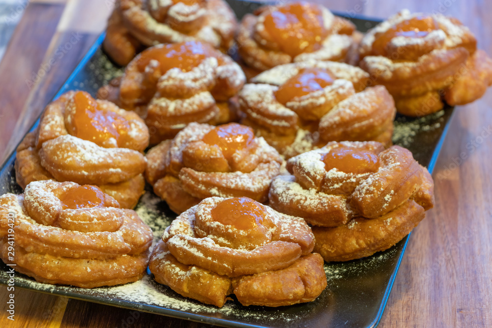 Hungarian home made pastry called rózsafánk rose pastry or doughnuts after frying with powdered sugar and apricots marmalade topping 