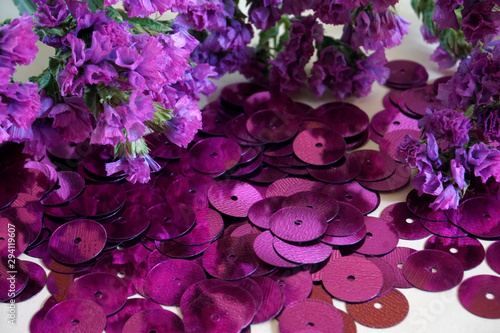 Detail of purple round sequins and purple dried flowers.