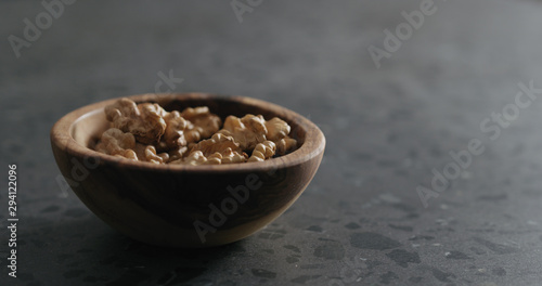 walnut kernels in wooden bowl on terrazzo countertop