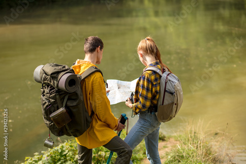 Couple backpackers standing near the lake, styding the map. back view photo. close up portrait, travle, tourism photo