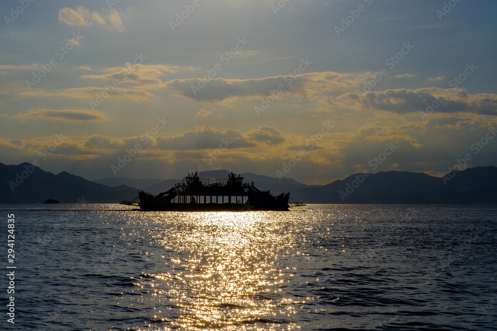 Ferry passing in the sunset backlight, HIroshima bay, Japan