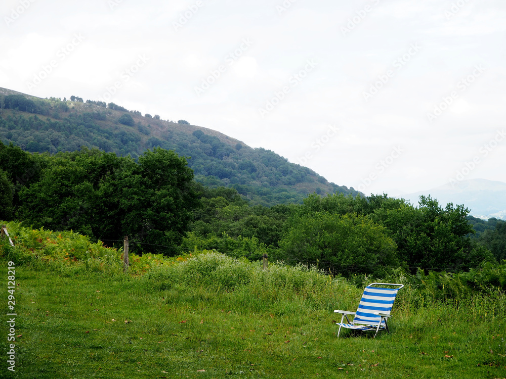 Una silla de playa en medio de la montaña. Concepto de relax, vacaciones.