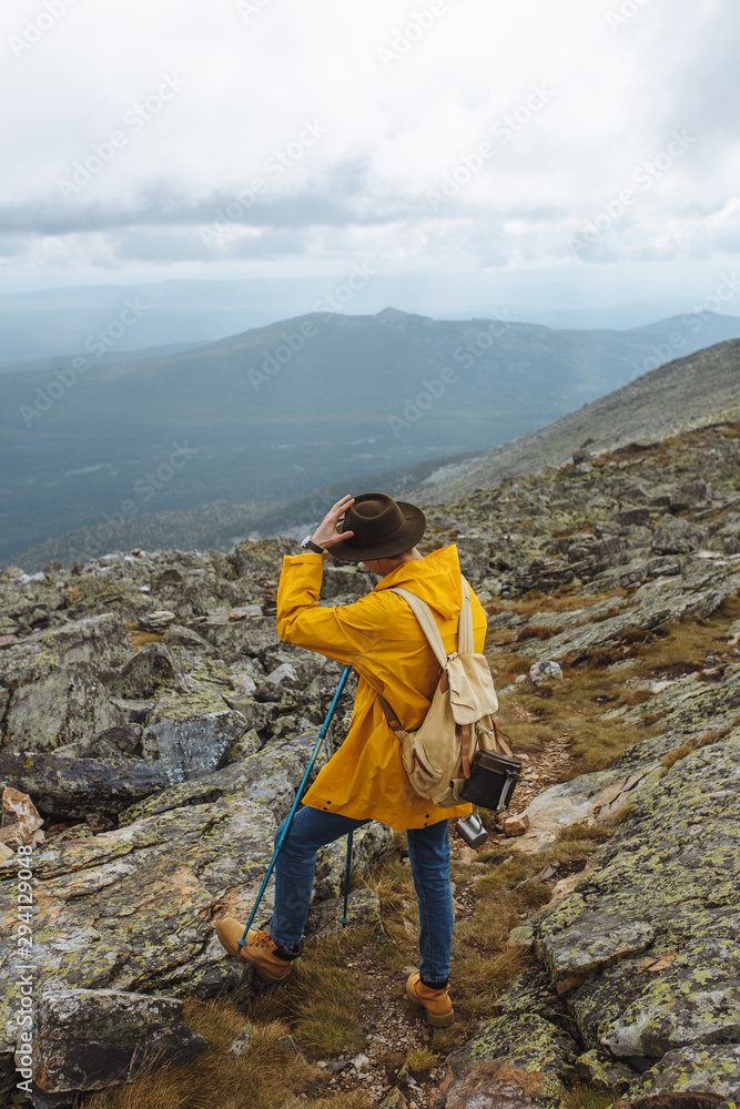 Fototapeta premium tired hiker having a break after long travel, tiredness, wanderer taking off hat looking at the distance.