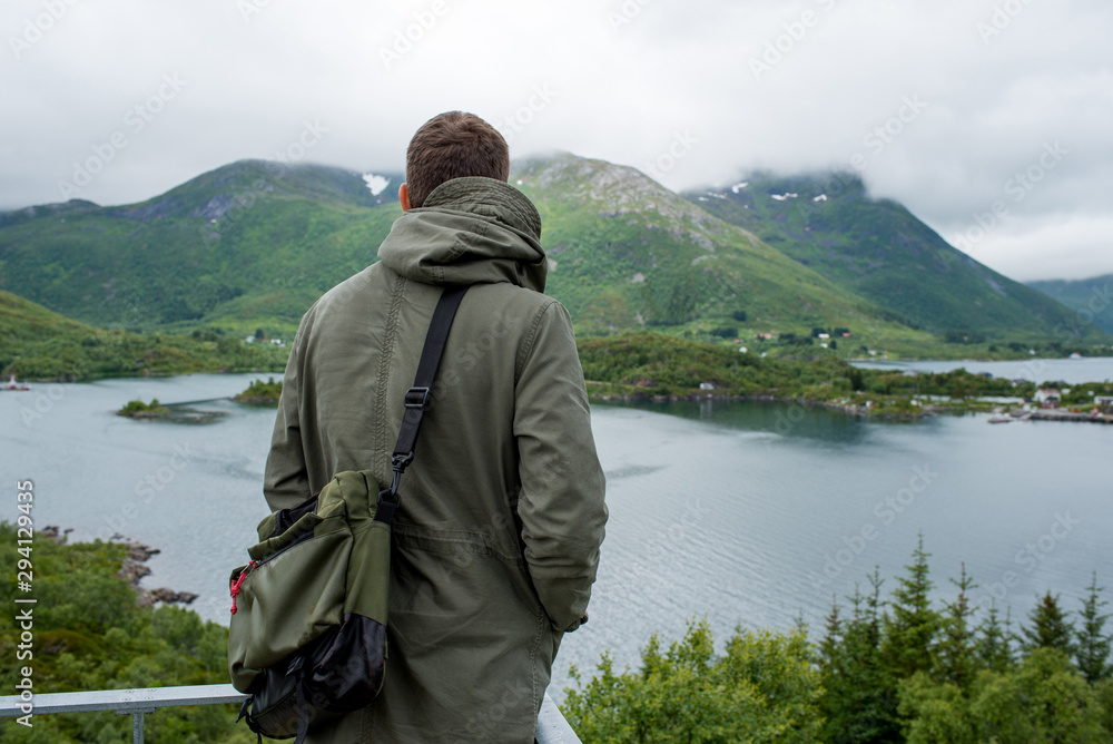 A men enjoy the scenic nature. Northern beauty panoramic view. Fjord, ocean and mountain landscape. Travel, adventure. Sense of freedom, relax lifestyle. Explore North Norway. Summer in Scandinavia