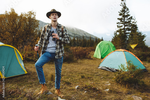 young man holding binoculars exploring the area, full length photo.hobby, interest