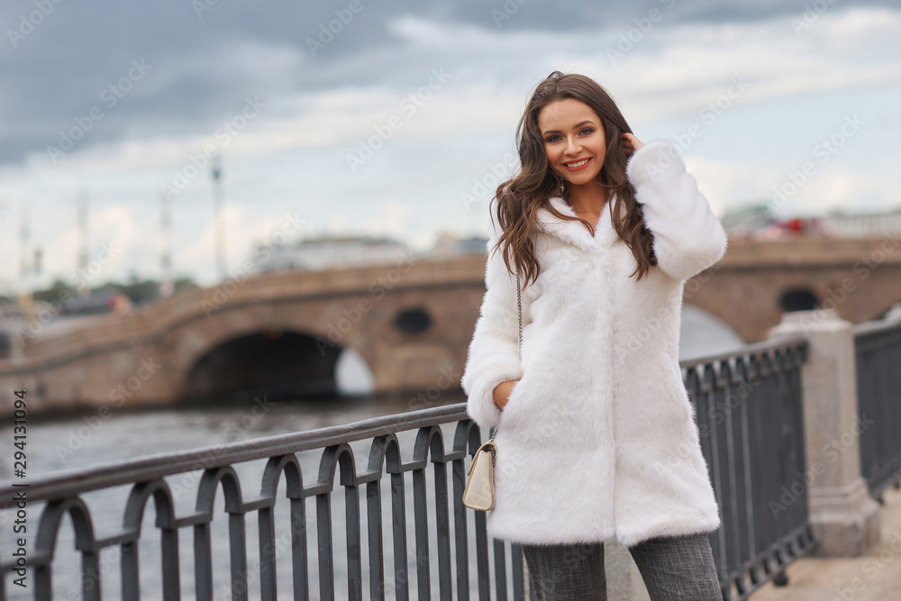Young beautiful stylish woman walking down the street on a cold winter ...