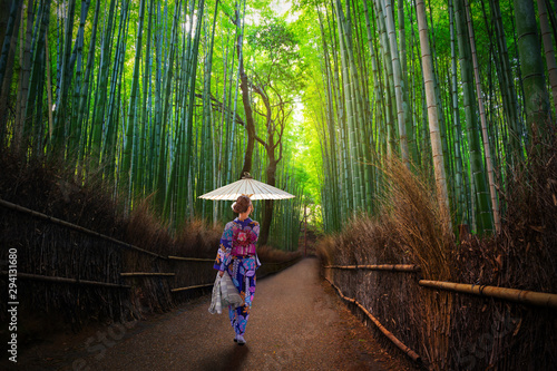 Bamboo forest at Arashiyama with woman in traditional kinono and umbrella. Japan