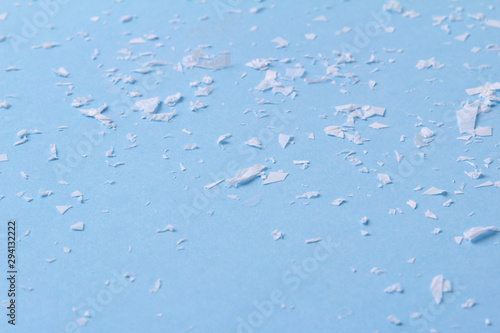 White artificial snow on blue background with copy space.