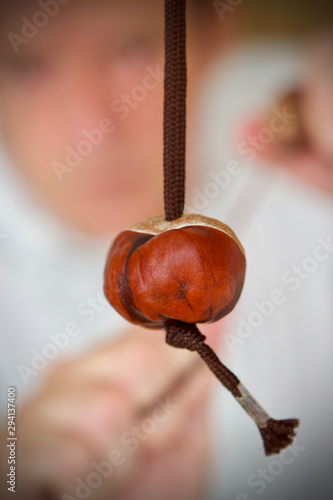 Cuacasian boy playing a game of conkers