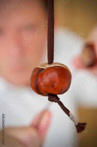 Cuacasian boy playing a game of conkers