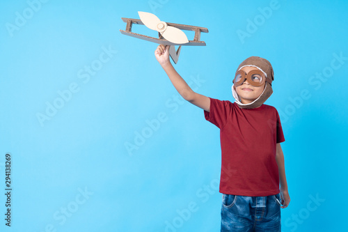 kid in red shirt dream as pilot holding plane paper