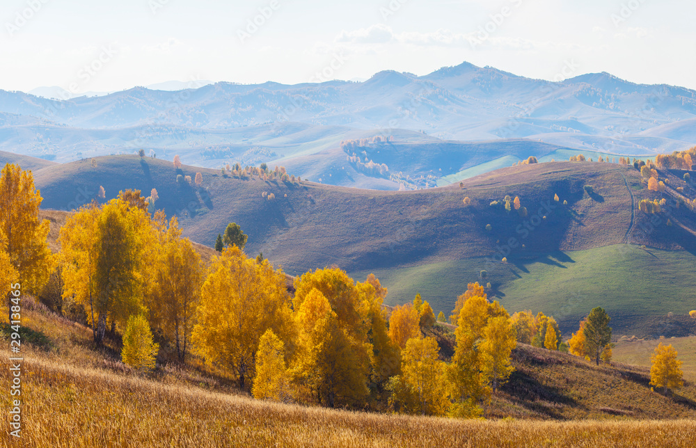 Autumn view. The picturesque valley. Forested slopes and mountains in the distance in a blue haze. Autumn view. The picturesque valley. Forested slopes and mountains in the distance in a blue haze.