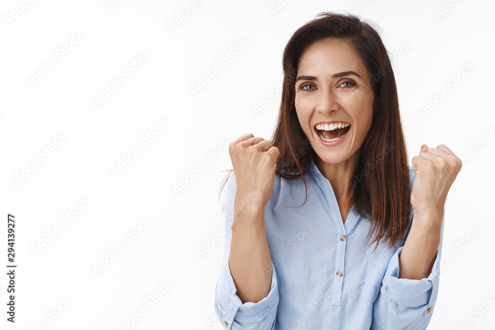 Lucky happy cheerful brunette mother triumphing son won, achieve goal, fist pump joyfully smiling, support daughter football match, grinning, celebrating good news, victory sign, white background