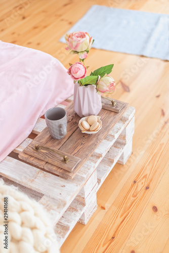  Tray with a romantic breakfast and rose (tea, cakes and a bouquet of peonies) in the bedroom in pastel colors