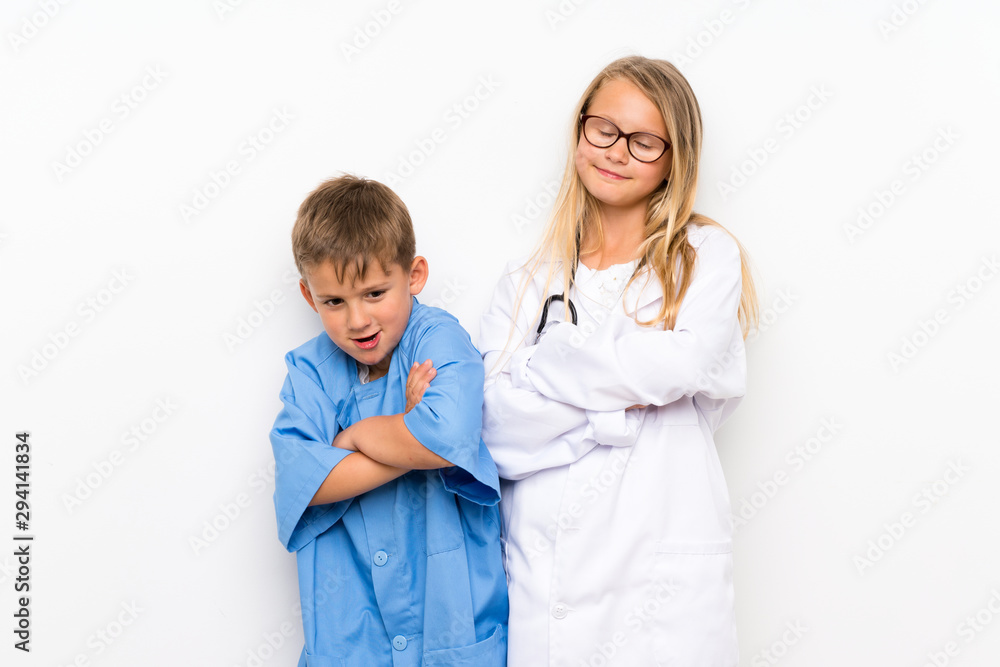 Little brothers playing to be doctors over isolated white wall Little brothers playing to be doctors over isolated white wall